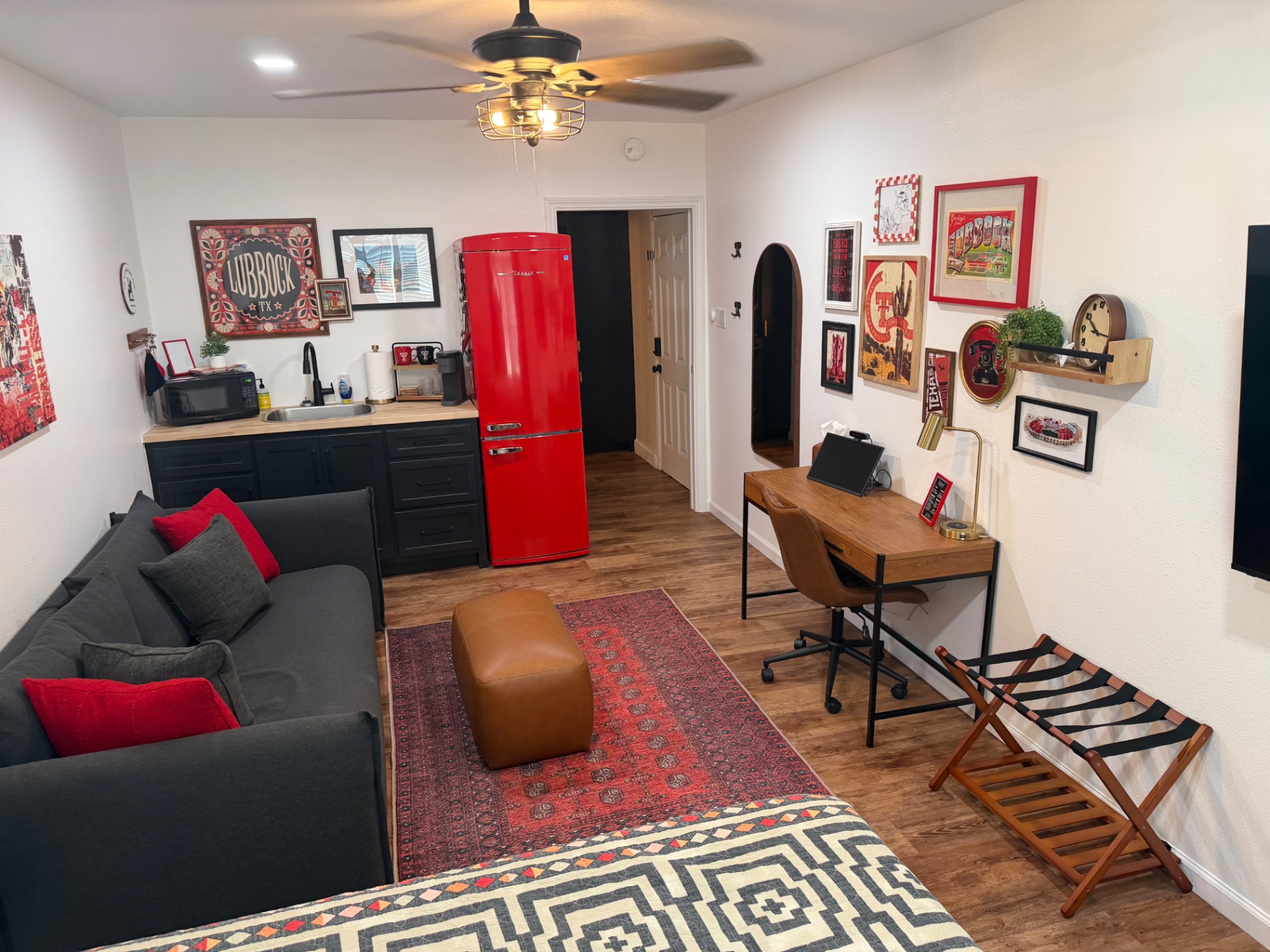 Teal garage apartment behind the main house with a grassy backyard — Living area & kitchenette