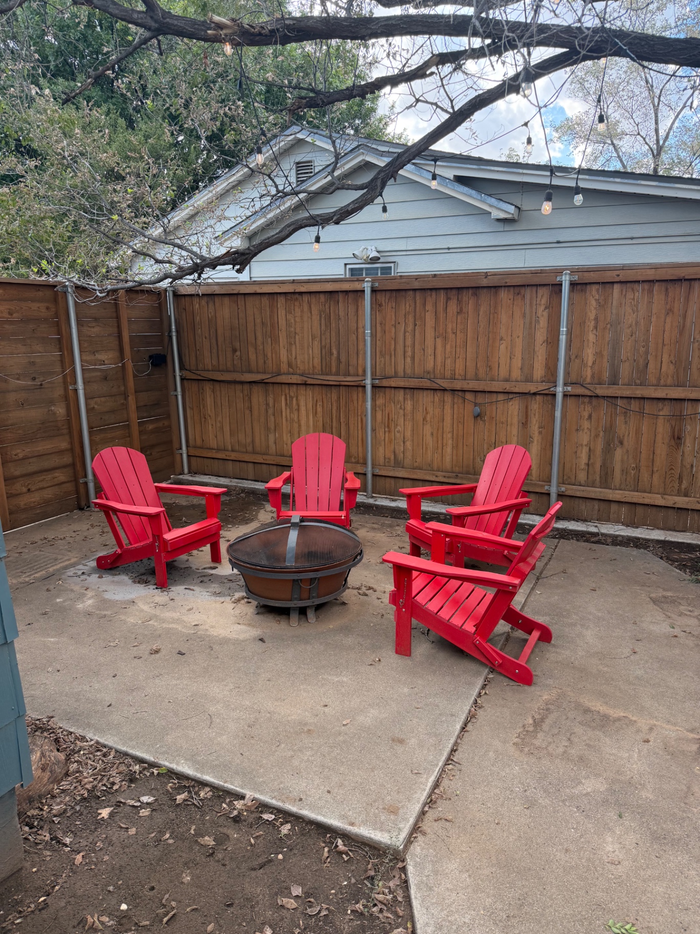 Teal garage apartment behind the main house with a grassy backyard — Backyard fire pit